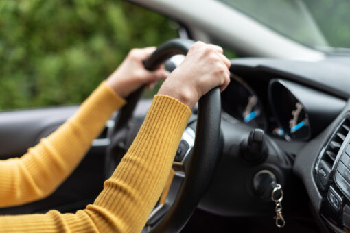 Vodič držiaci volant automobilu, ktorý počas jazdy ťahá do strany v dôsledku nesprávnej geometrie kolies alebo poruchy riadenia.