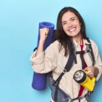 Turista stojaci na horskom chodníku s ruksakom, obklopený prírodou.