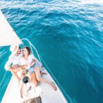 Jachta plávajúca po mori počas západu slnka.